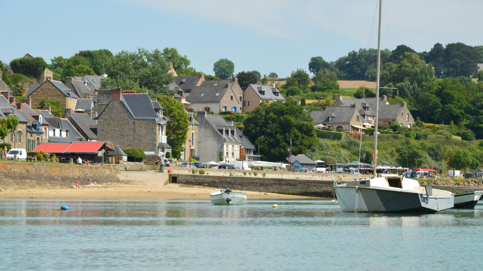 Tranquil scene of Saint-Suliac in Brittany, showcasing waterfront houses and boats.