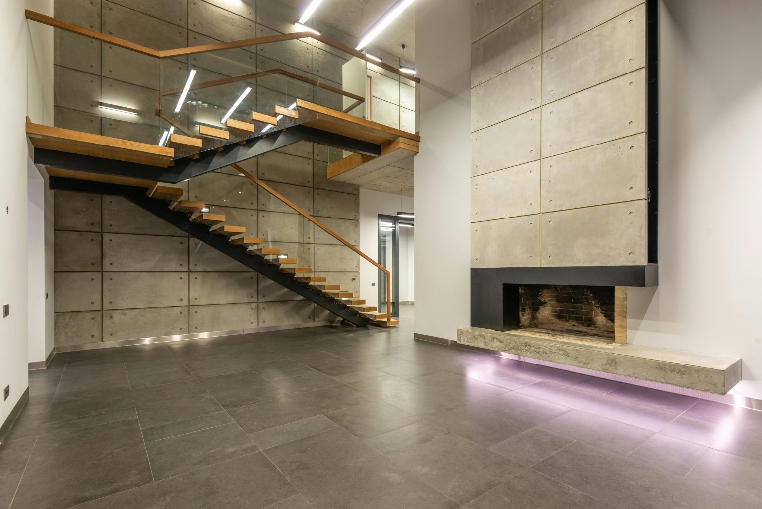 Spacious modern interior featuring a minimalist staircase and fireplace.