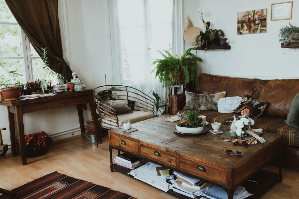 A cozy living room with vintage furniture, rustic decor, and indoor plants creating a warm ambiance.