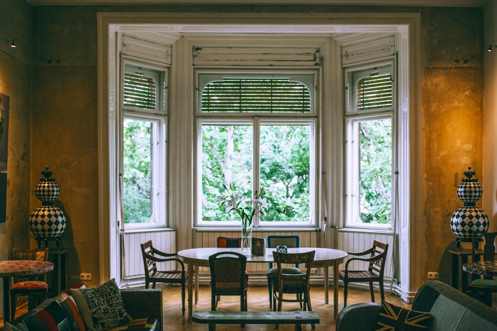 Interior of cozy room with chairs around wooden table and old vintage elements