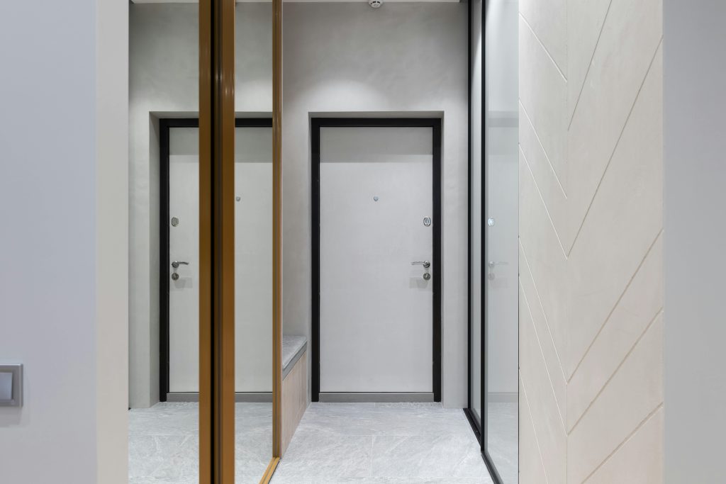 Perspective view of hall with white walls and wardrobes designed with mirrors