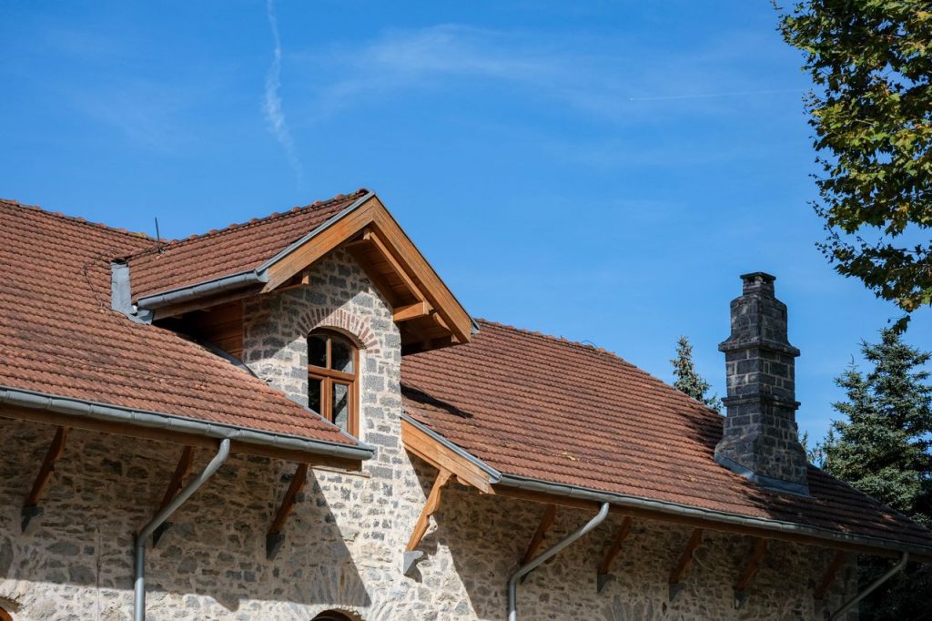 Rustic stone house with red roof and chimney, under a clear blue sky in İstanbul, Türkiye.